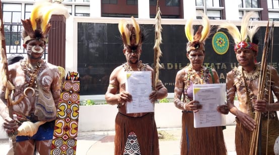 Quatre Papous en tenue traditionnelle devant le tribunal
