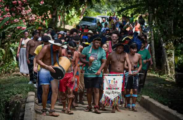 Un groupe de personnes d’origine afro-brésilienne et d’origine autochtone lors d’un défilé dans la forêt tropicale