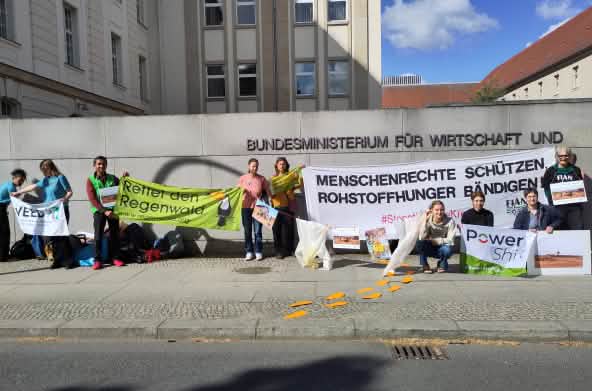 Des personnes tiennent des pancartes devant le mur du ministère fédéral allemand de l’Économie et de l’Énergie à Berlin