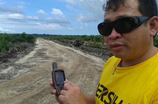 Matek Geram avec un GPS sur une plantation de palmiers à huile