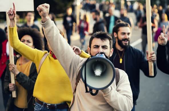 Homme hurlant dans un mégaphone lors d’une manifestation