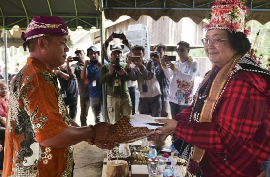 Willem Hengki remet une pétition à Siti Nurbaya, avec de nombreux photographes en arrière-plan