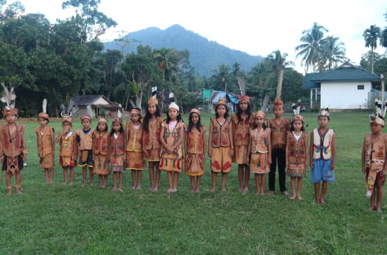 Enfants Dayak en habits traditionnels avec pour arrière plan les montagnes de Bornéo