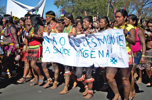 Des femmes indigènes protestent avec une banderole contre la destruction de leurs forêts et zones protégées au Brésil