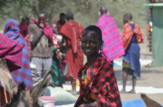 Femmes et hommes Massaï sur un marché, une femme regarde la caméra