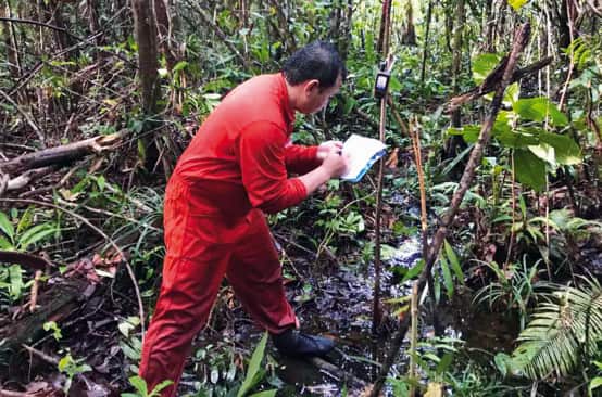 Matek fait des relevés dans la forêt à l’aide de son GPS pour cartographier le territoire des Iban