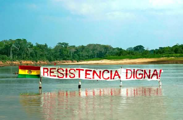 Bannière sur un fleuve dans la forêt tropicale de Bolivie : « Résister est une question de dignité » peut-on lire sur la bannière à côté du drapeau bolivien
