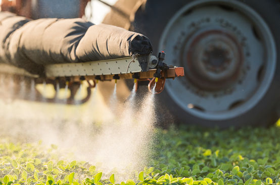Un tracteur est en train d’épandre des pesticides sur un champ dans l’Union européenne