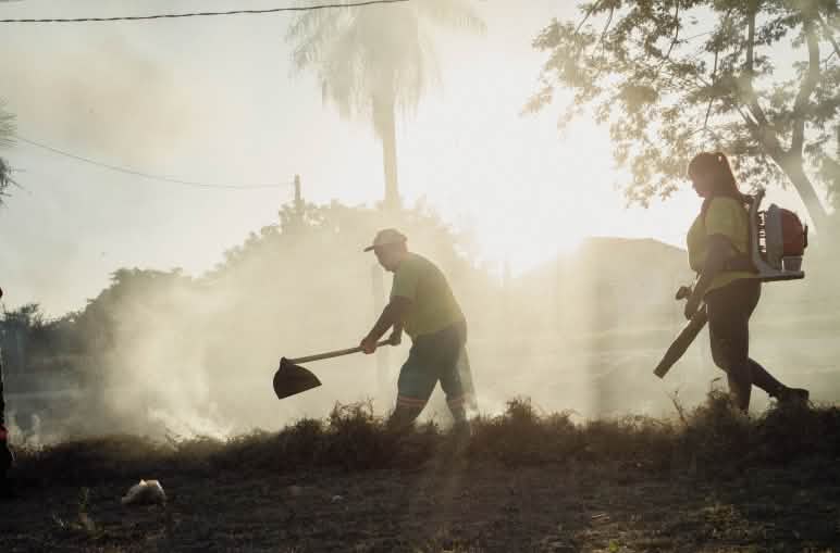 Un homme muni d’un batteur à feu et une femme avec un souffleur mobile lors d’un exercice éclairé par le soleil à contre-jour.