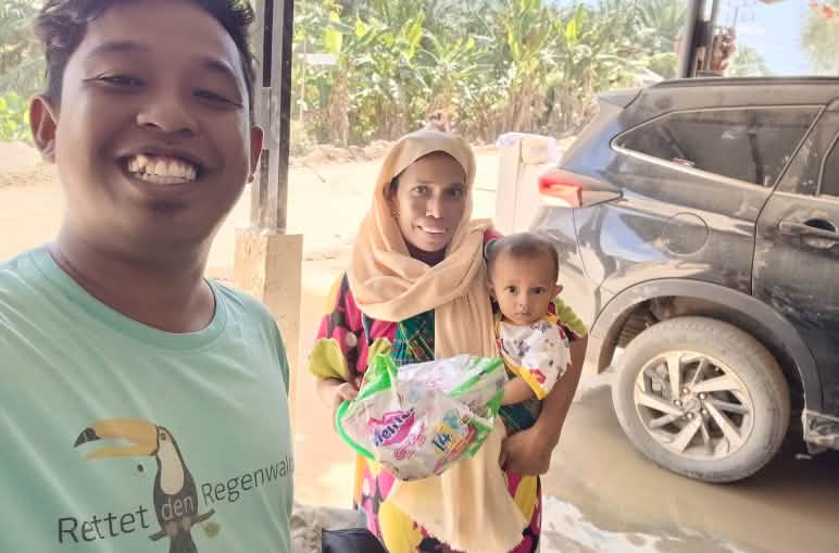 Syukur avec un t-shirt RdR et une femme avec un bébé