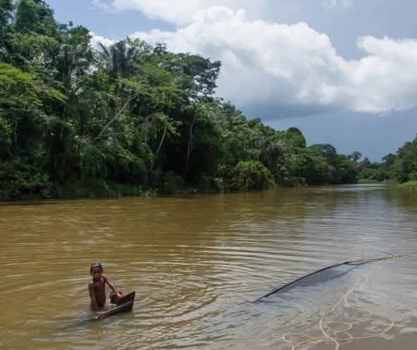 Enfant murui se baignant dans le río Caquetá en Colombie
