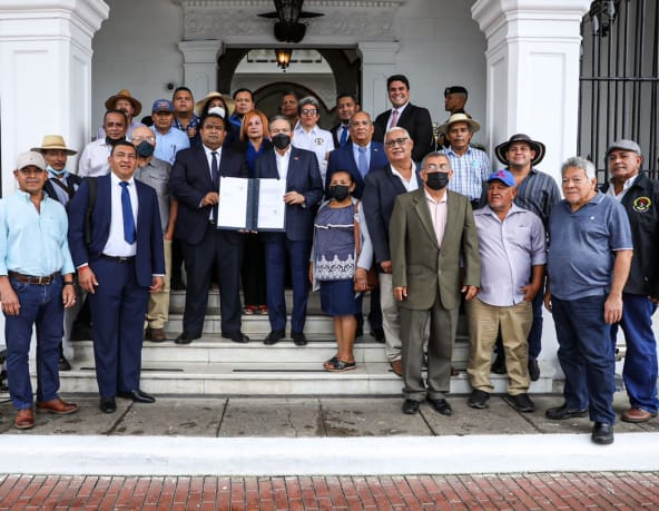 Un groupe d’une vingtaine de personnes entoure le président du Panama sur le perron du palais présidentiel pour présenter la loi signée