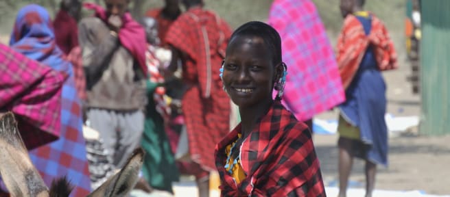 Femmes et hommes Massaï sur un marché, une femme regarde la caméra