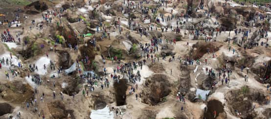 Le coltan est au cœur des conflits violents qui secouent la République démocratique du Congo (© MONUSCO/Sylvain Liechti/CC BY-SA 2.0) Vue aérienne au-dessus d’une mine, avec trous profonds, en partie remplis d’eau, entre lesquels se trouvent de nombreuses personnes