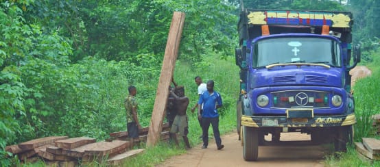 Des hommes chargent des planches sur un camion au Nigeria