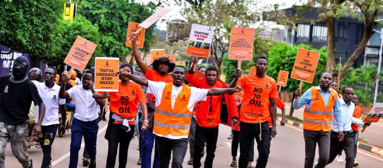 Des jeunes gens habillés en orange marchent au milieu de la rue
