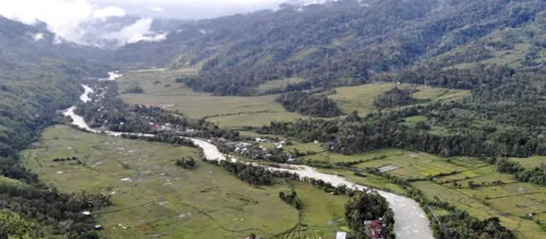 Vue aérienne par drone d’une vallée traversée par une rivière et parsemée de petits villages