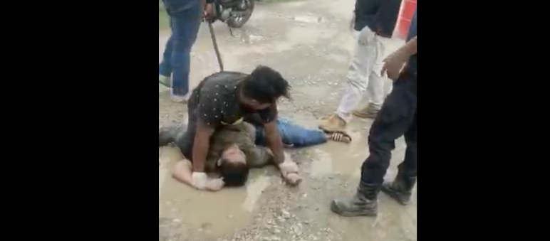 Capture d’écran d’une vidéo envoyée par notre partenaire : derrière la victime se tient l’un des agresseurs avec un bâton Un villageois est battu par des employés d’une plantation d’huile de palme au Sarawak