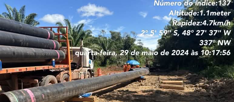 Un camion semi-remorque décharge des tronçons de conduite de pipeline dans la zone déboisée d’un chantier en Amazonie