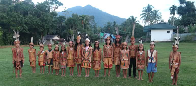 Enfants Dayak en habits traditionnels avec pour arrière plan les montagnes de Bornéo