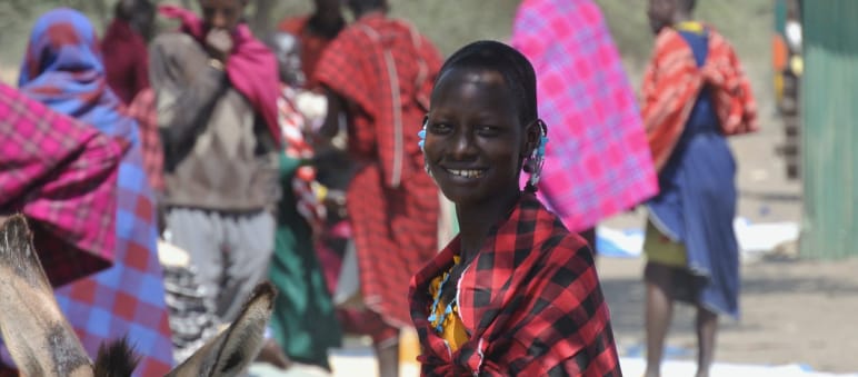 Femmes et hommes Massaï sur un marché, une femme regarde la caméra