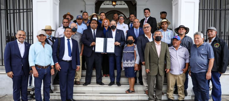 Un groupe d’une vingtaine de personnes entoure le président du Panama sur le perron du palais présidentiel pour présenter la loi signée