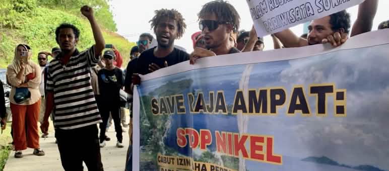 Des manifestants brandissant une banderole sur laquelle est écrit : « Sauvez Raja Ampat : Stop au nickel ».
