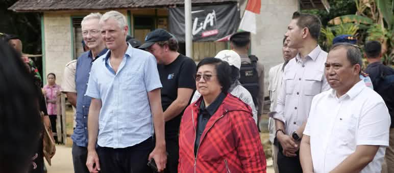 Femme avec une veste rouge dans un groupe avec plusieurshommes