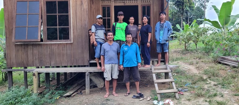 Sept personnes devant une maison en bois