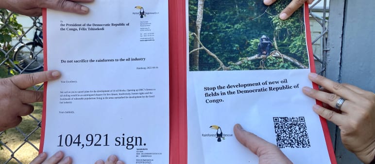Nous protégeons la forêt tropicale ensemble Des mains de différentes personnes sur notre pétition devant l’ambassade de la RDC à Berlin