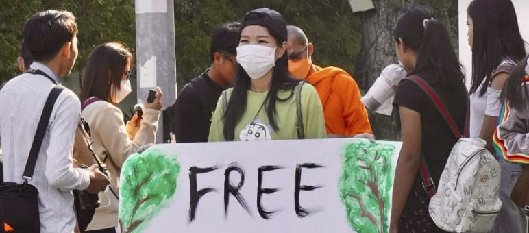 Une militante tient une grande pancarte sur laquelle on peut lire « Free Mother Nature Activist ! »