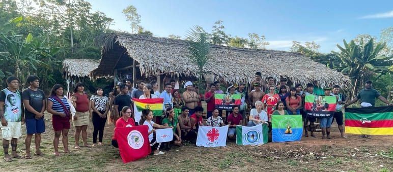 Un groupe de personnes dans le territoire autochtone Ka’apor pose avec des drapeaux