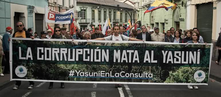 Manifestation du mouvement “Yasunidos” à Quito : « La corruption tue le Yasuní » Un cortège défile dans une rue avec une grande banderole portant le slogan, en espagnol, « La corruption tue le Yasuní »