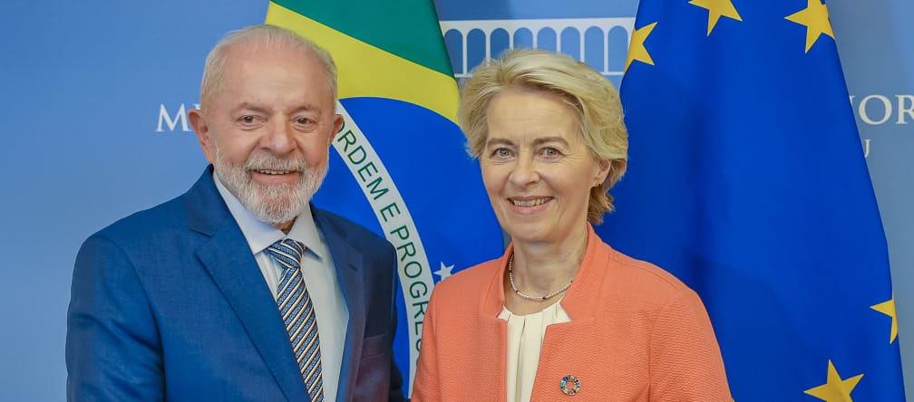 La présidente de la Commission européenne, Ursula von der Leyen, et le président du Brésil, Lula da Silva, se serrent la main devant les drapeaux brésiliens et européens