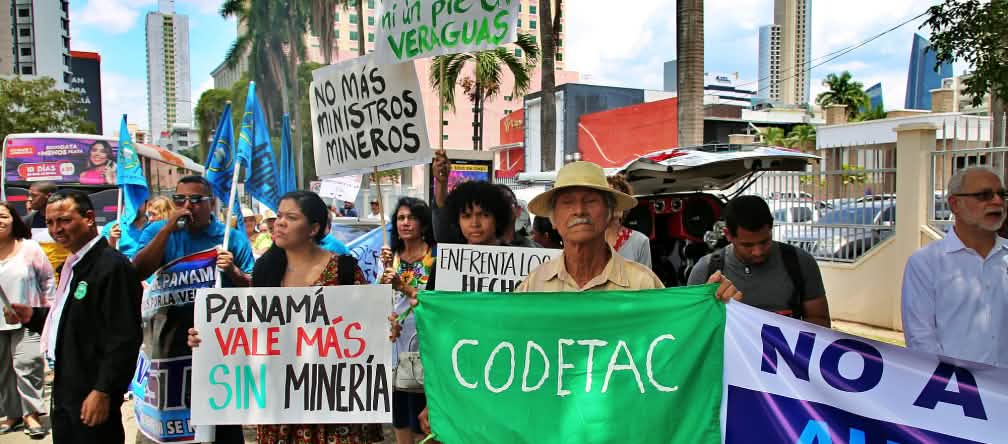Des personnes portant des pancartes peintes à la main protestent contre l’exploitation minière dans la capitale du Panama