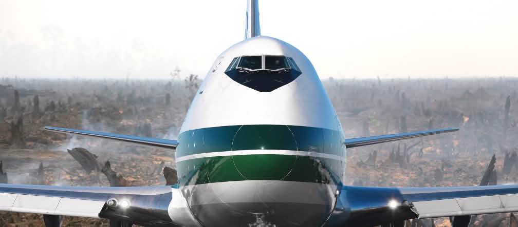 Photomontage : un avion de face avec en arrière-plan les cendres encore fumantes d'une forêt tropicale venant d'être incendiée