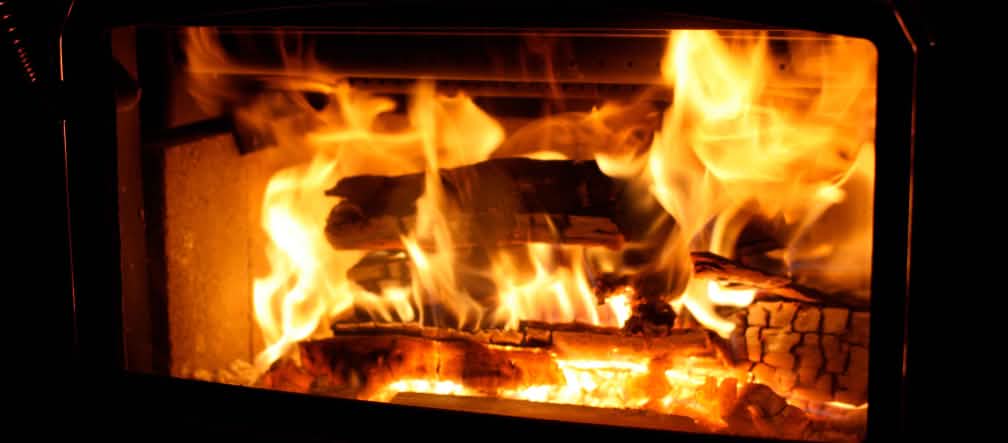 Des bûches de bois en train de brûler dans une cheminée