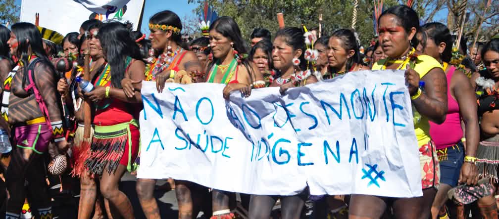 Des femmes indigènes protestent avec une banderole contre la destruction de leurs forêts et zones protégées au Brésil