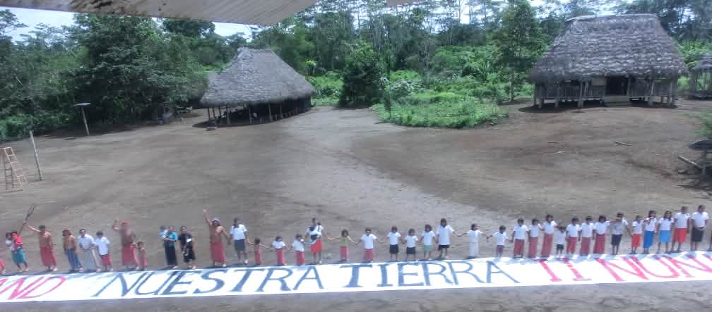 Indiens de l'Equateur luttant contre l'exploitation pétrolière dans leur forêt Chaîne humaine avec une bannière contenant l’inscription "Nuestra tierra" (Notre terre)