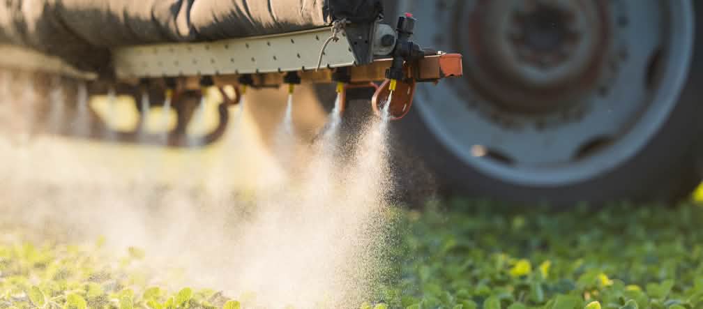 Le glyphosate peut et doit être interdit par les gouvernements des pays européens Un tracteur est en train d’épandre des pesticides sur un champ dans l’Union européenne