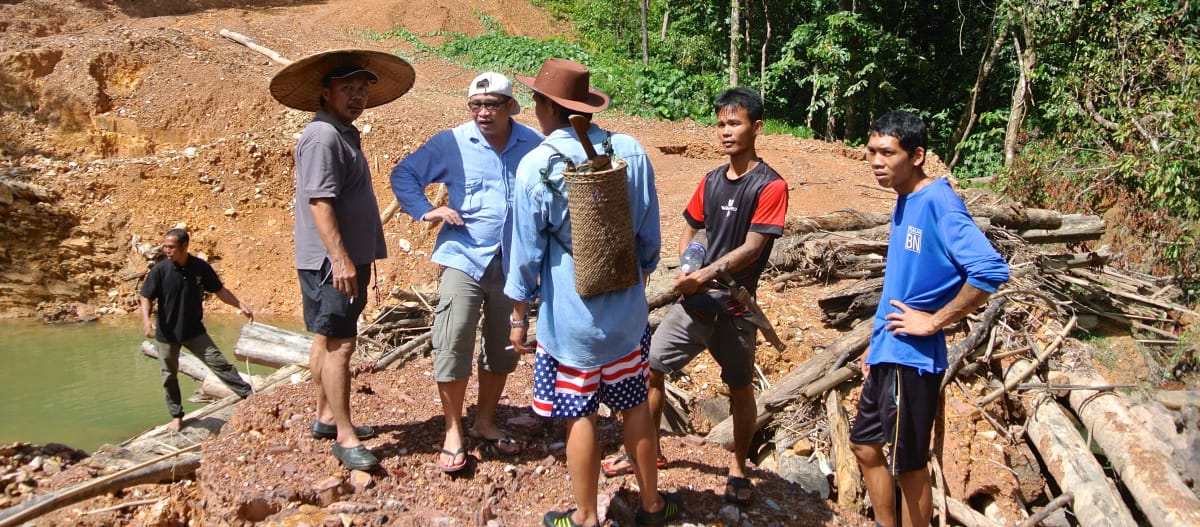 Des autochtones du peuple Iban se tiennent sur une piste aménagée illégalement par des bûcherons au Sarawak