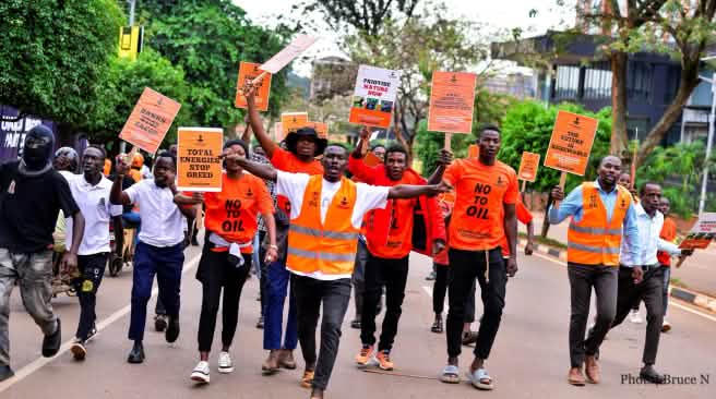 Des jeunes gens habillés en orange marchent au milieu de la rue