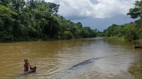 Enfant murui se baignant dans le río Caquetá en Colombie