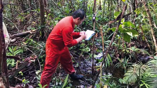 Matek fait des relevés dans la forêt à l’aide de son GPS pour cartographier le territoire des Iban