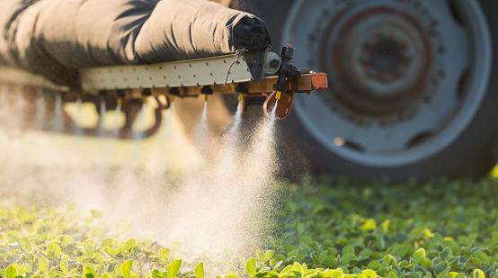 Un tracteur est en train d'épandre des pesticides sur un champ dans l'Union européenne