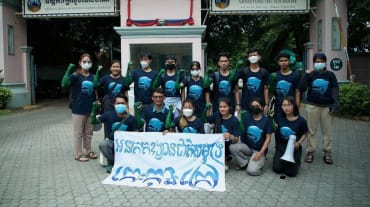 15 jeunes gens sont debout et agenouillés devant le bâtiment du ministère du Tourisme à Phnom Penh. Ils tiennent une bannière sur laquelle est écrit en cambodgien : "L’île de Koh Kong doit devenir un parc national marin"