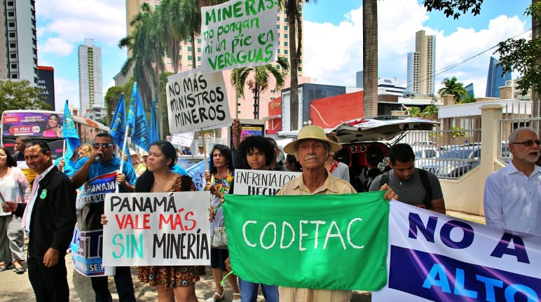 Des personnes portant des pancartes peintes à la main protestent contre l’exploitation minière dans la capitale du Panama