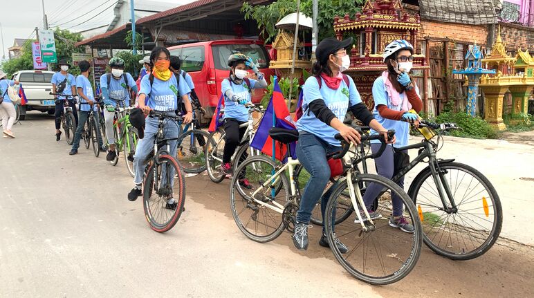 8 jeunes militants partent manifester dans une rue sur leurs vélos