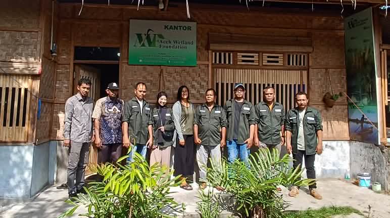 Sauvons la forêt a rencontré ses partenaires d’Aceh Wetland Forum sur le terrain en 2023 Photo de groupe de la biologiste Rita Glaus de Sauvons la forêt entourée de l’équipe de l’organisation AWF devant son bureau, un édifice en rotin et bambou
