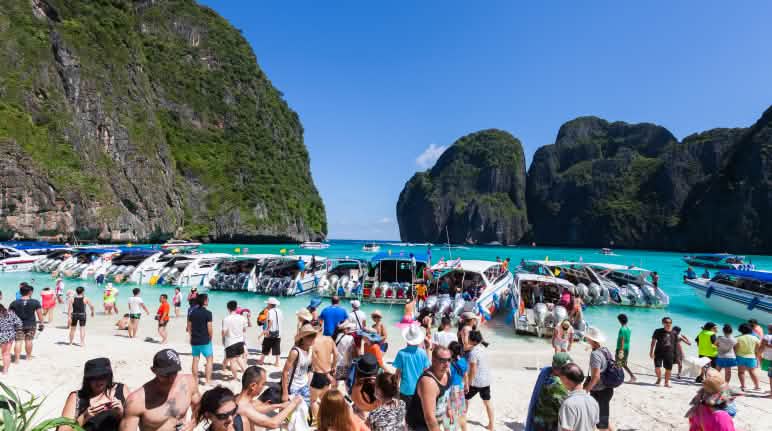 Des touristes arrivent en bateau à Maya Beach Des touristes à Maya Beach, Ko Phi Phi, Thaïlande